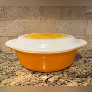 Pyrex Cinderella casserole dish in orange, with a "Sunflower" pattern on the lid